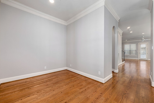 spare room with ceiling fan, light wood-type flooring, and crown molding