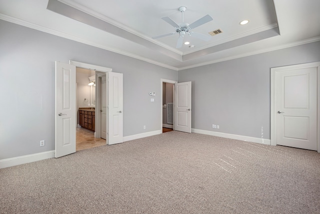 unfurnished bedroom featuring a raised ceiling, crown molding, ceiling fan, and light colored carpet