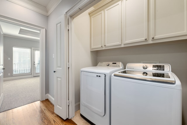 washroom featuring cabinets, light colored carpet, crown molding, and washing machine and clothes dryer