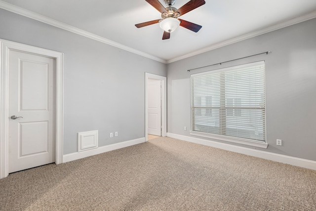 carpeted spare room featuring ceiling fan and ornamental molding