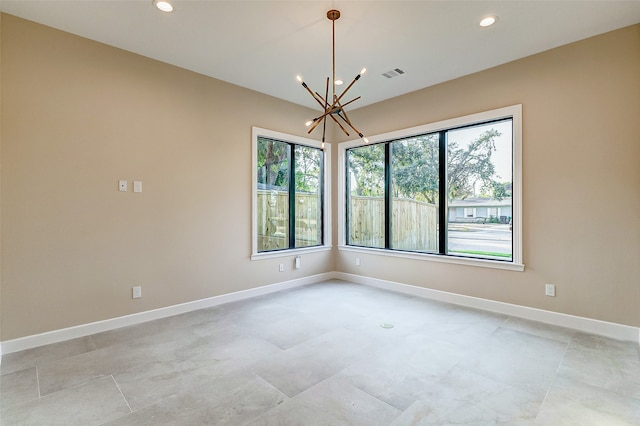 unfurnished room featuring a notable chandelier and a wealth of natural light