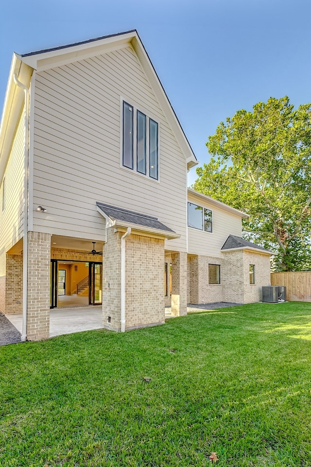 rear view of house with a patio area, a lawn, and central AC unit