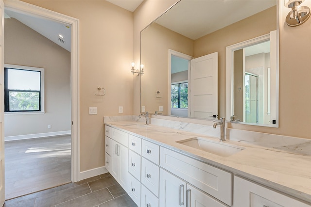 bathroom featuring vanity, hardwood / wood-style flooring, walk in shower, and vaulted ceiling