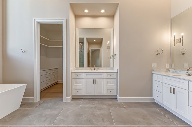 bathroom with vanity, a bathing tub, and tile patterned floors