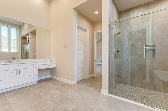 bathroom with a shower with door, vanity, and tile patterned floors