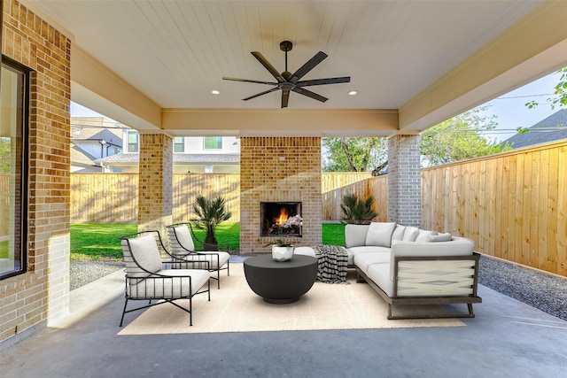 view of patio / terrace featuring an outdoor living space with a fireplace and ceiling fan