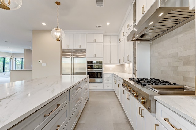 kitchen featuring backsplash, appliances with stainless steel finishes, decorative light fixtures, and white cabinets