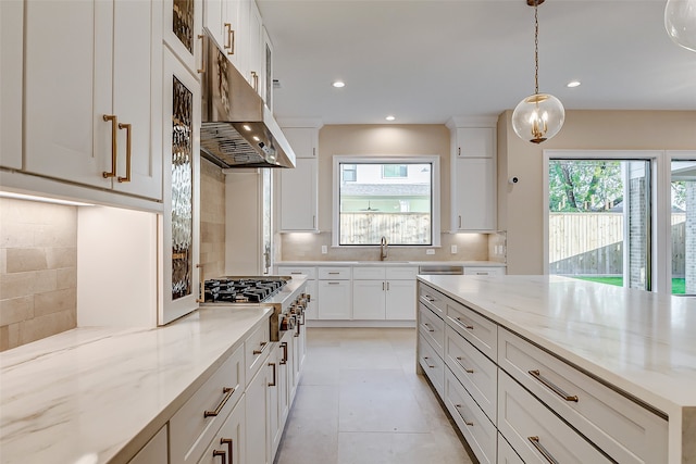 kitchen with white cabinetry, light stone counters, pendant lighting, and backsplash