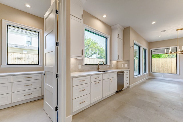 kitchen with sink, white cabinetry, decorative light fixtures, and tasteful backsplash