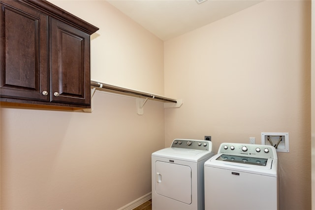 laundry area with washing machine and dryer and cabinets