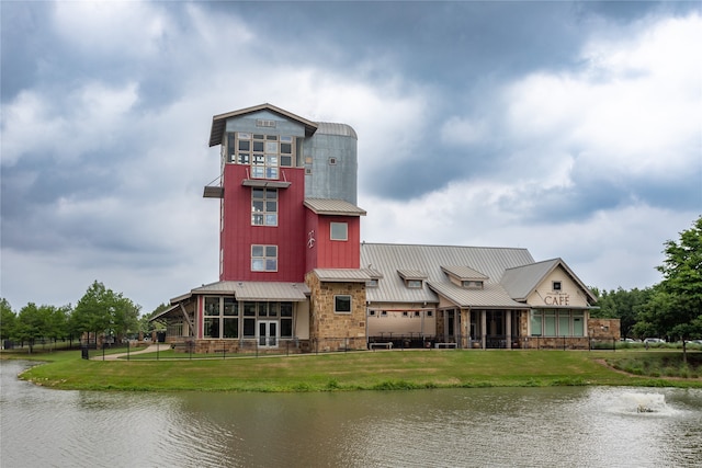 exterior space featuring a front lawn and a water view