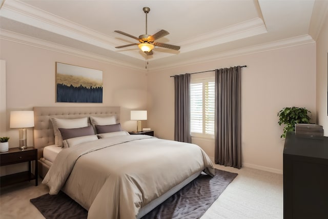 carpeted bedroom featuring ornamental molding, a tray ceiling, and ceiling fan