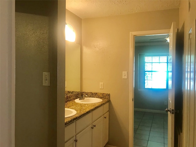 bathroom with vanity, ceiling fan, tile patterned floors, and a textured ceiling