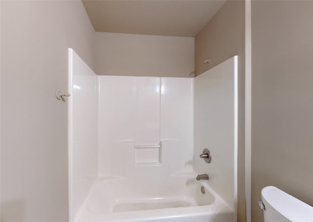 bathroom featuring  shower combination, a textured ceiling, and toilet