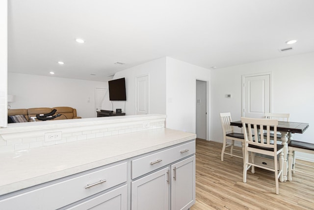 122 Austin Rd, Angleton, TX 77515 - kitchen featuring light wood finished floors, open floor plan, visible vents, light countertops, and recessed lighting
