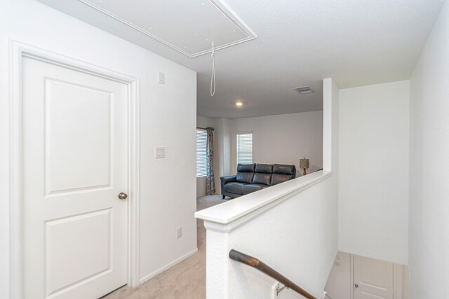 122 Austin Rd, Angleton, TX 77515 - corridor featuring light colored carpet, attic access, an upstairs landing, visible vents, and baseboards