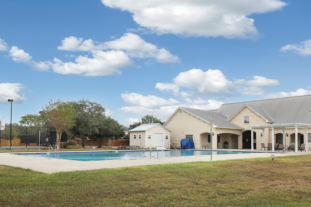 view of pool featuring a patio, a yard, and an outdoor structure