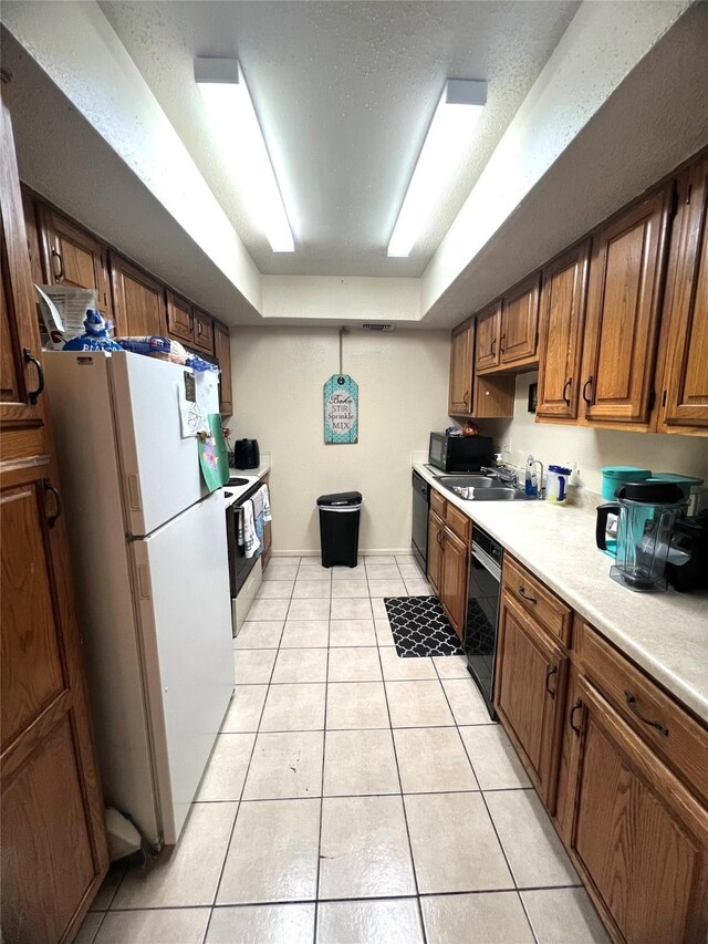 2830 S Bartell Dr Unit 39, Houston, TX 77054 - kitchen featuring black appliances, light tile patterned flooring, light countertops, a raised ceiling, and a sink