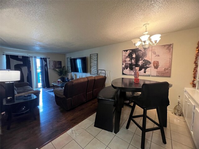 2830 S Bartell Dr Unit 39, Houston, TX 77054 - dining room with a chandelier, a textured ceiling, and light wood-style flooring