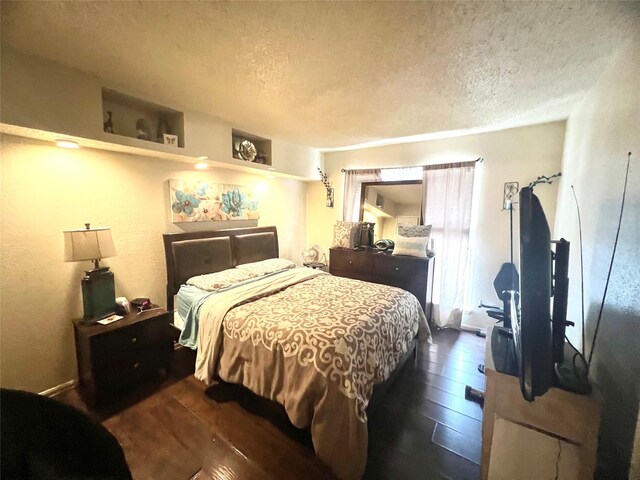 2830 S Bartell Dr Unit 39, Houston, TX 77054 - bedroom featuring a textured ceiling and dark wood-style floors