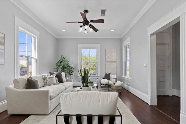 living room featuring dark wood-type flooring, crown molding, a healthy amount of sunlight, and ceiling fan