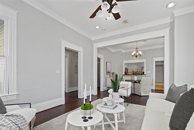 living room with crown molding, dark hardwood / wood-style floors, and ceiling fan with notable chandelier