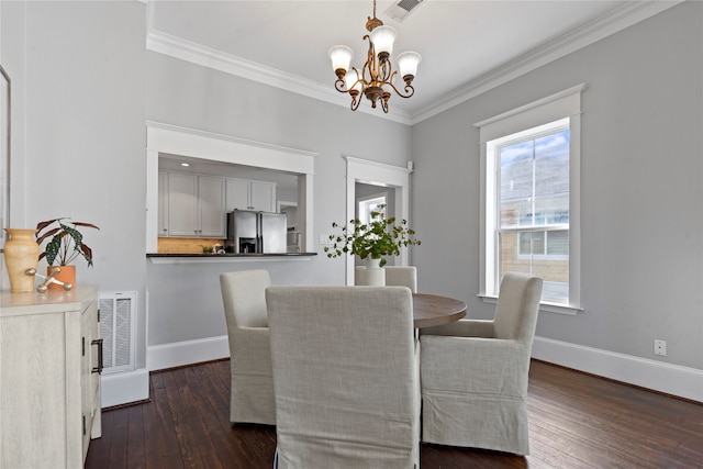 dining area with a notable chandelier, ornamental molding, and dark wood-type flooring