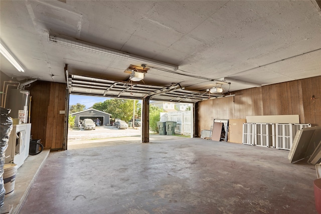 garage featuring wood walls, a garage door opener, and water heater