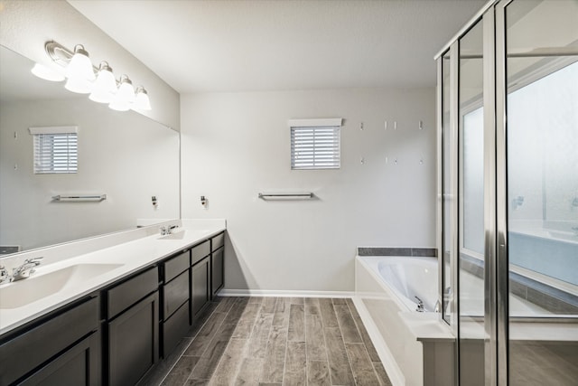 bathroom featuring vanity, plus walk in shower, hardwood / wood-style flooring, and a healthy amount of sunlight