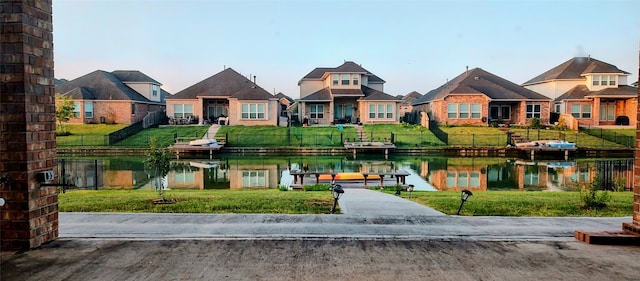 view of home's community with a yard and a water view