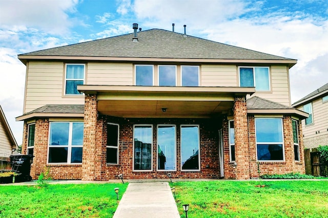 rear view of property featuring a lawn