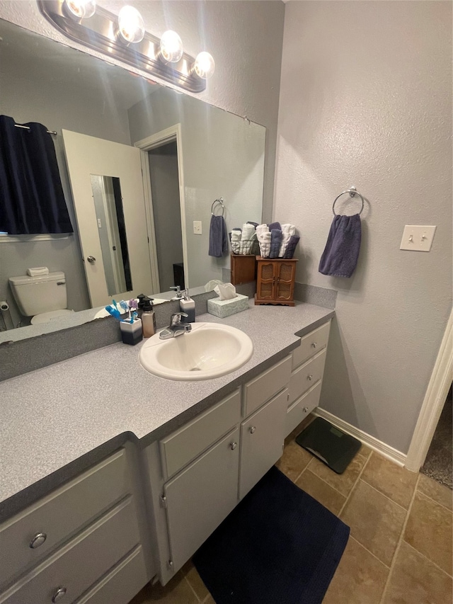 bathroom with vanity, toilet, and tile patterned floors