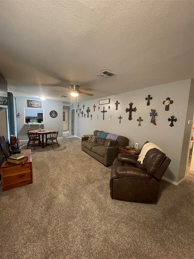 carpeted living room with a textured ceiling and ceiling fan