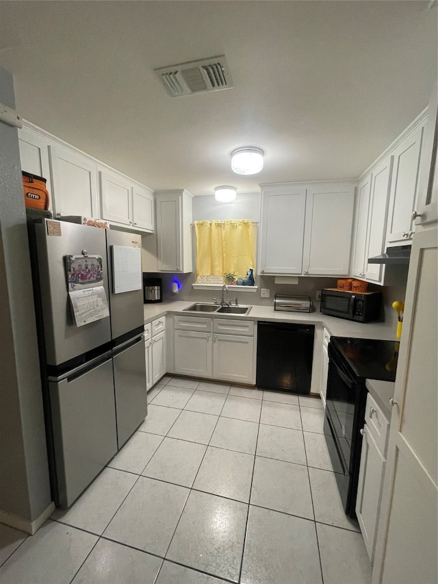 kitchen with sink, black appliances, white cabinets, and light tile patterned floors