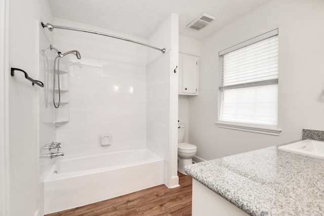 full bathroom featuring shower / bathing tub combination, hardwood / wood-style floors, vanity, and toilet