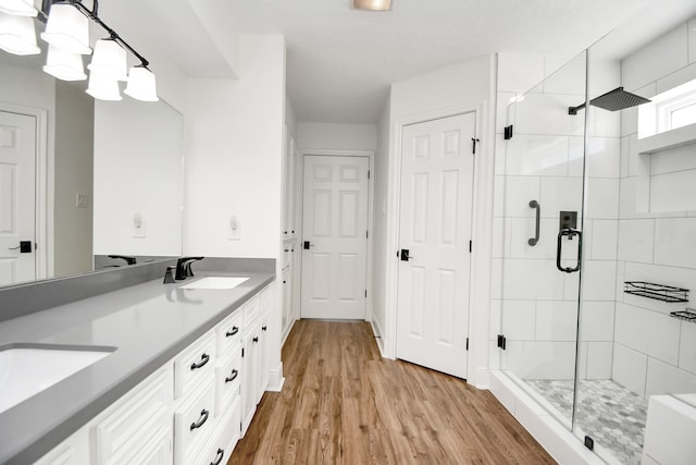 bathroom with vanity, hardwood / wood-style flooring, and walk in shower