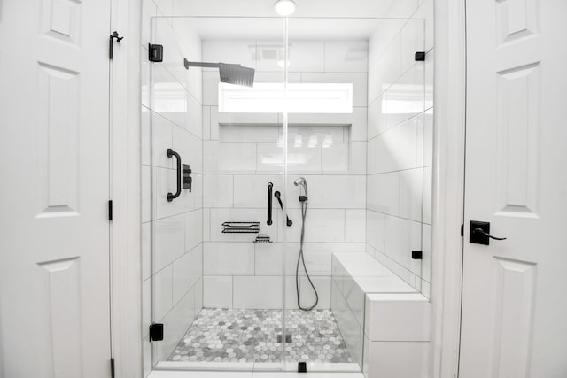 bathroom featuring a shower with door