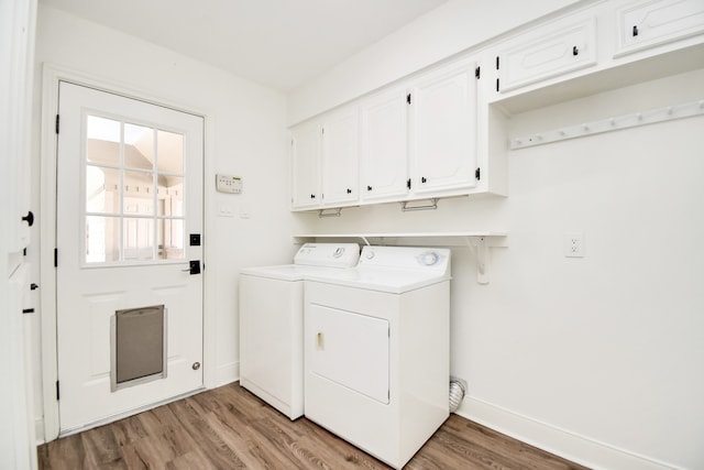 washroom featuring independent washer and dryer, cabinets, and light wood-type flooring