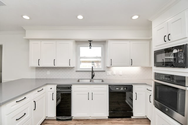 kitchen featuring white cabinetry, sink, crown molding, decorative backsplash, and black appliances