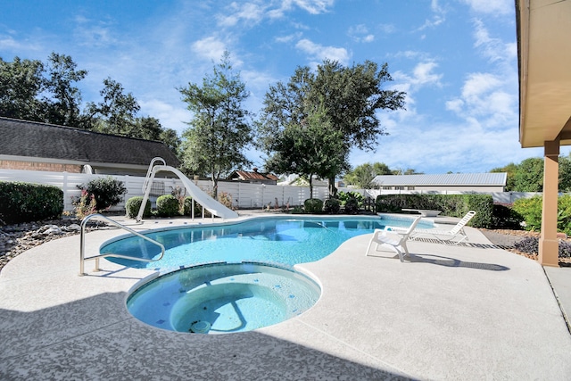 view of pool with an in ground hot tub, a patio, and a water slide