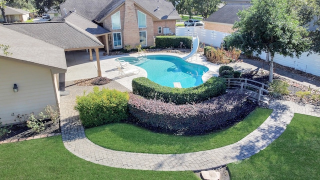 view of swimming pool with a lawn, a patio, and a water slide