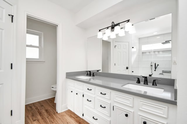 bathroom featuring hardwood / wood-style floors, vanity, toilet, and walk in shower