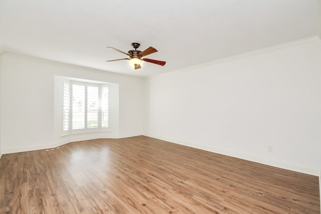 spare room featuring wood-type flooring, ceiling fan, and crown molding