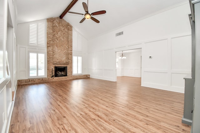 unfurnished living room with beamed ceiling, high vaulted ceiling, a fireplace, ceiling fan with notable chandelier, and light wood-type flooring