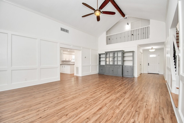 unfurnished living room with beam ceiling, light hardwood / wood-style flooring, high vaulted ceiling, and ceiling fan