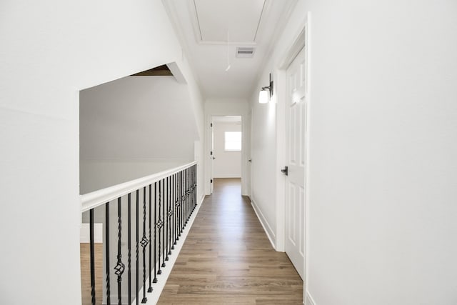 hallway with wood-type flooring and ornamental molding