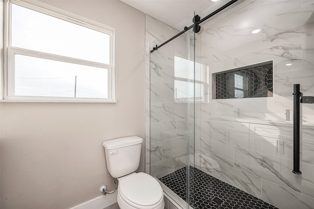 bathroom featuring toilet and a shower with door