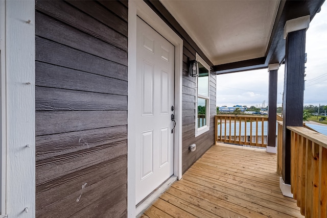 wooden deck featuring a water view and covered porch