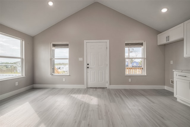 interior space with high vaulted ceiling, plenty of natural light, and light hardwood / wood-style flooring