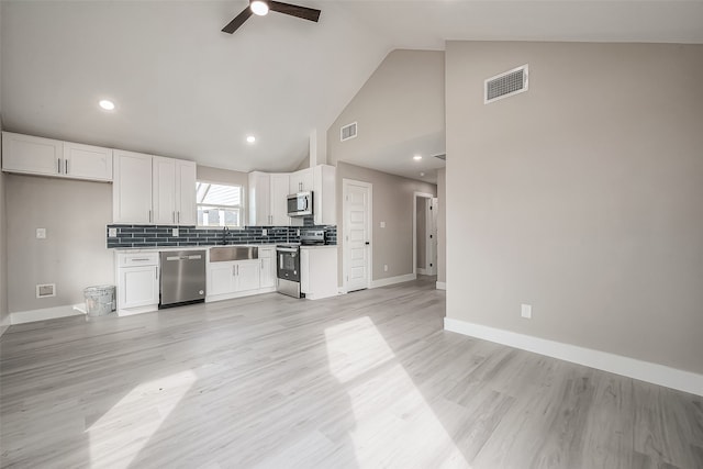 kitchen featuring white cabinets, light hardwood / wood-style flooring, sink, high vaulted ceiling, and appliances with stainless steel finishes